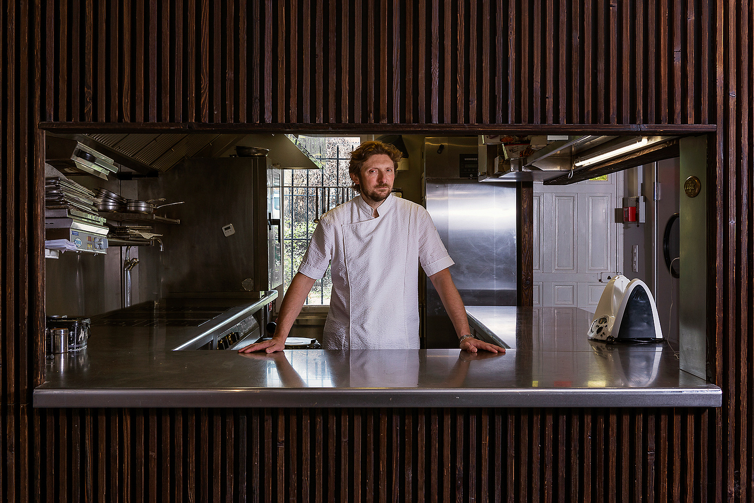 Portrait de Sylvain Joffre dans sa cuisine, chef étoile du restaurant gastronomique En Pleine Nature à Toulouse.
