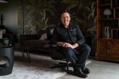 Portrait en situation de Thierry Merville, chef du restaurant la Table des Merville à Toulouse. Il est assis sur un fauteuil.