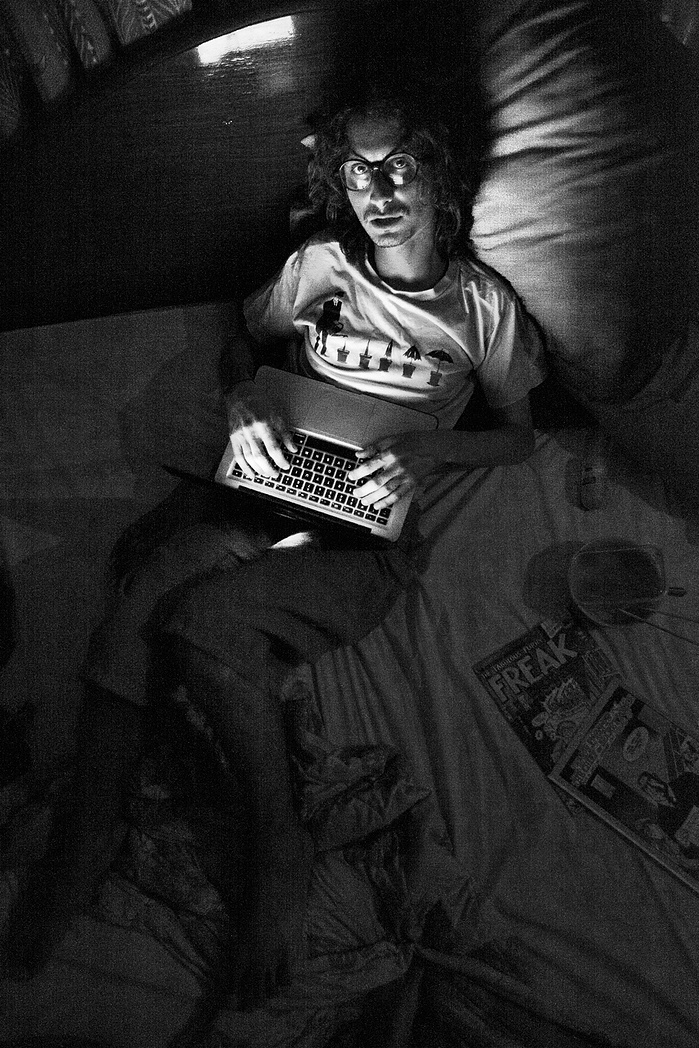 Black + White Fine Art Portrait of a young Turkish man on his bed, lit by the light of his computer with freak comics next to him.
Fine Art Portrait
Black + White Photography
Fine Art Gallery
Artistic Photography
Ring Light Photography