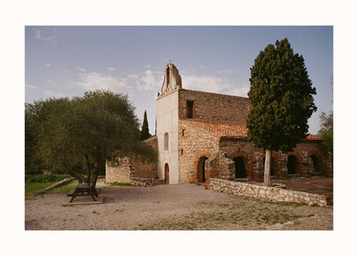 Fine Art print edition of 7 signed & numbered. 50x70 or 30x40 cm on Hahnemühle Bright White paper. Olivier Montay photographer. The Saint-Vincent chapel with rough stone walls and an ocher tiled roof. A bushy tree in front of the arcades. Film photography