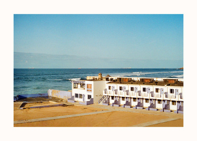 Fine Art print edition of 7 signed & numbered. 50x70 or 30x40 cm on Hahnemühle Bright White paper. Olivier Montay photographer. Row of small white buildings, seafront, Atlantic Ocean. Morocco. Film photography
