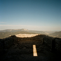 In the ruins of a castle overlooking an indiscernible landscape, on a terrace in the open air, the sun draws a rectangle of brilliant light among the shadows. France, Occitanie, Pyrenees-Orientales, Peyrepertuse, April 2022