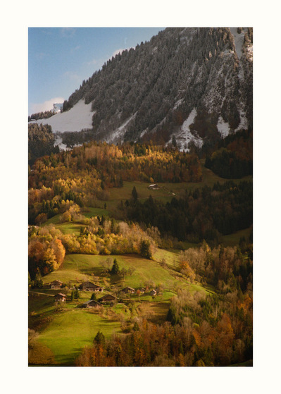 Fine Art print edition of 7 signed & numbered. 50x70 or 30x40 cm on Hahnemühle Bright White paper. Olivier Montay photographer. Golden light illuminates a hamlet at the mountain's base. Autumnal vegetation. France, haute-Savoie. Film photography