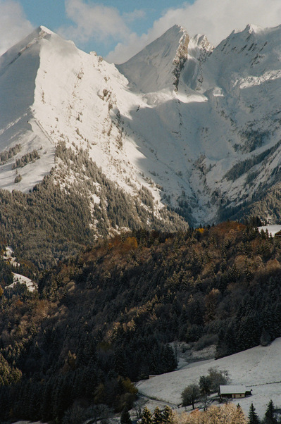 Snow-capped peaks. Slopes are covered with vegetation of a uniformly brown autumn hue. A small chalet with a snow-covered roof is located below, in the shade of the mountains. France, Auvergne-Rhône-Alpes, Haute-Savoie, Manigod, 2021
Pentes enneigées