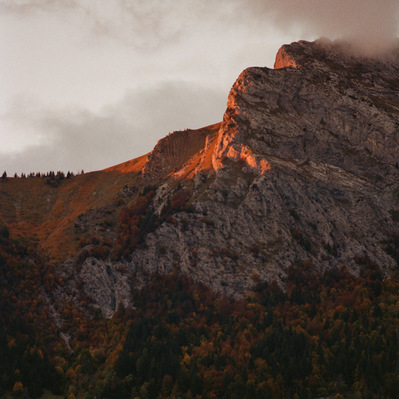 Rocky summit of a mountain lighted in red by sunset. Vegetation slopes, as well as a chalet located in a grassy clearing, are already plunged into darkness. France, Auvergne-Rhône-Alpes, Haute-Savoie, Thônes, 2021
Montagne au soleil couchant