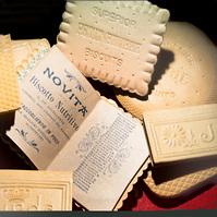 I calendari a forma di biscotti Lazzaroni sono realizzati utilizzando un cartoncino resistente e di alta qualità che viene sagomato per assumere la forma dei biscotti dell'azienda, come ad esempio gli Amaretti di Saronno. 