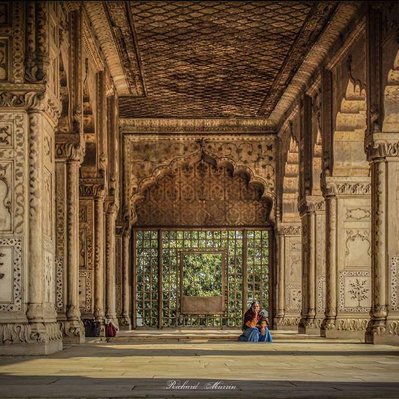 A high quality print available to buy of a woman waiting at the Red Fort, Delhi, India.