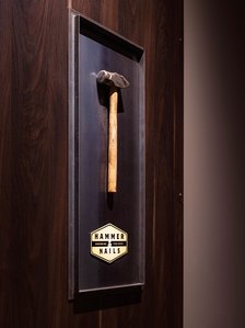 Graphic display panel with decorative frame, hammer and logo.