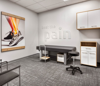 Treatment room interior and furnishing design for OrthoLazer health and wellness franchise.
