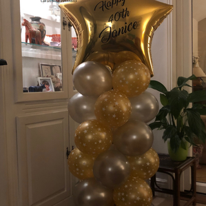This is a large golden star topped balloon pillar with a personalised message.