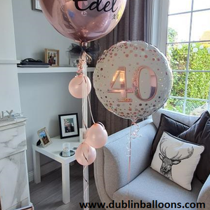 A Personalised pink and a personalised white balloon display for birthdays.