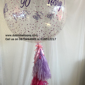 A very large personalised confetti balloon with a tassel.
