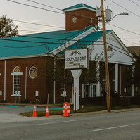 A Church sign reads: Accept what God allows. The red brick church sits behind