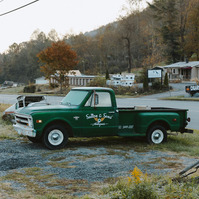 A vintage Chevrolet truck is used as an advert for an antique yard, covered in morning frost