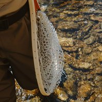Cropped in image detailing legs and a plastic net with the river in the background