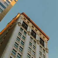 Evening light hits the top of a tall building 