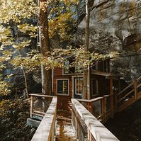 A cliffside cabin with wooden walkway surrounded by Autumn colours in Kentucky