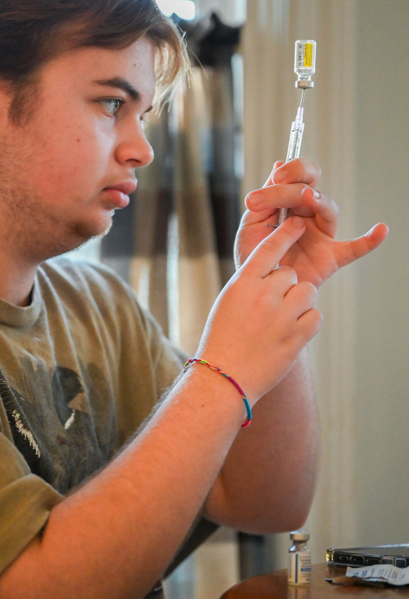 Jay prepares a syringe of his weekly 0.5 ml testosterone shot before injecting it into his thigh.