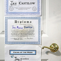 Certificates recognizing Jay’s elementary and middle school achievements hang on his closet door.