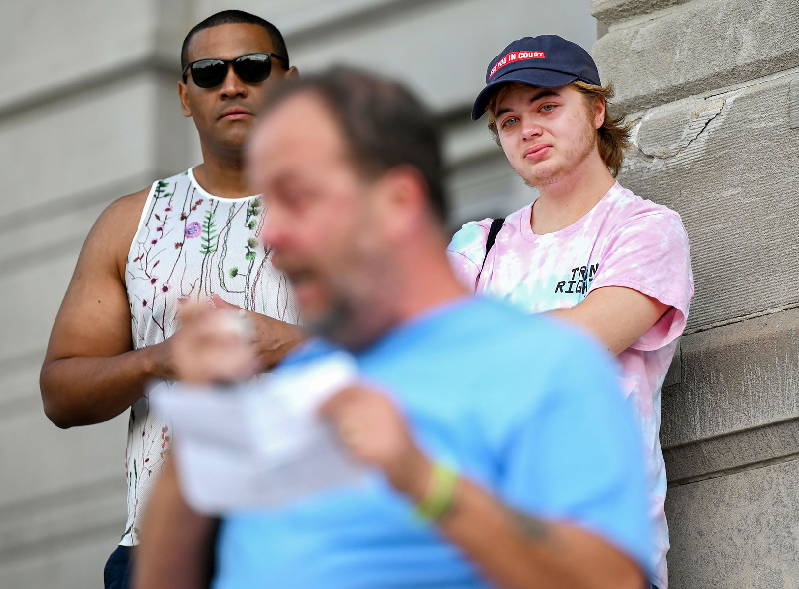 Jay, right, cries while listening to his dad, Harry Castilow, front, speak through tears about his experience raising a transgender child during a Keep Hate Out of Healthcare protest at Jesse Hall.
