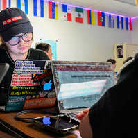 Jay works on his computer, which he has decorated with anti-incarceration, pro-choice and pro-LGBTQ+ rights stickers during English class.