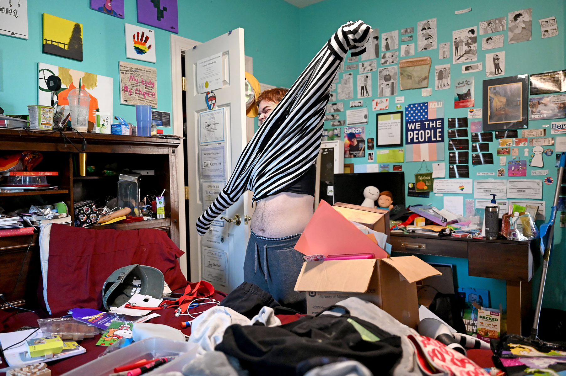 Jay Castilow, 17, pulls his Halloween costume over his binder in his bedroom.