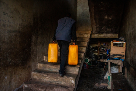 James, a Ligerian refugee carrying two 25 litres of water to his room at Oru International refugee camp, Nigeria.  Liberian Passport Liberia Refugee Civil War