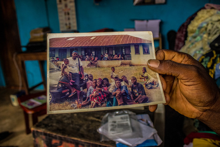 Taylor holds a group photo taken when they arrived at Oru International refugee camp, Nigeria. Liberian Liberia Refugee Civil War
