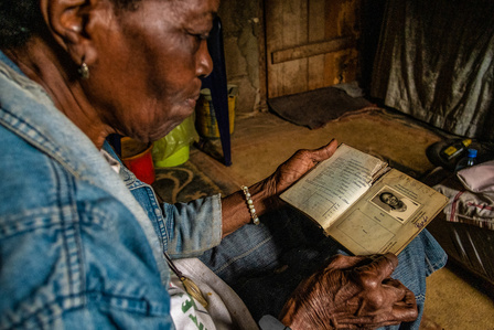 Mama Sckadee holding her old Liberian passport issued in 1982