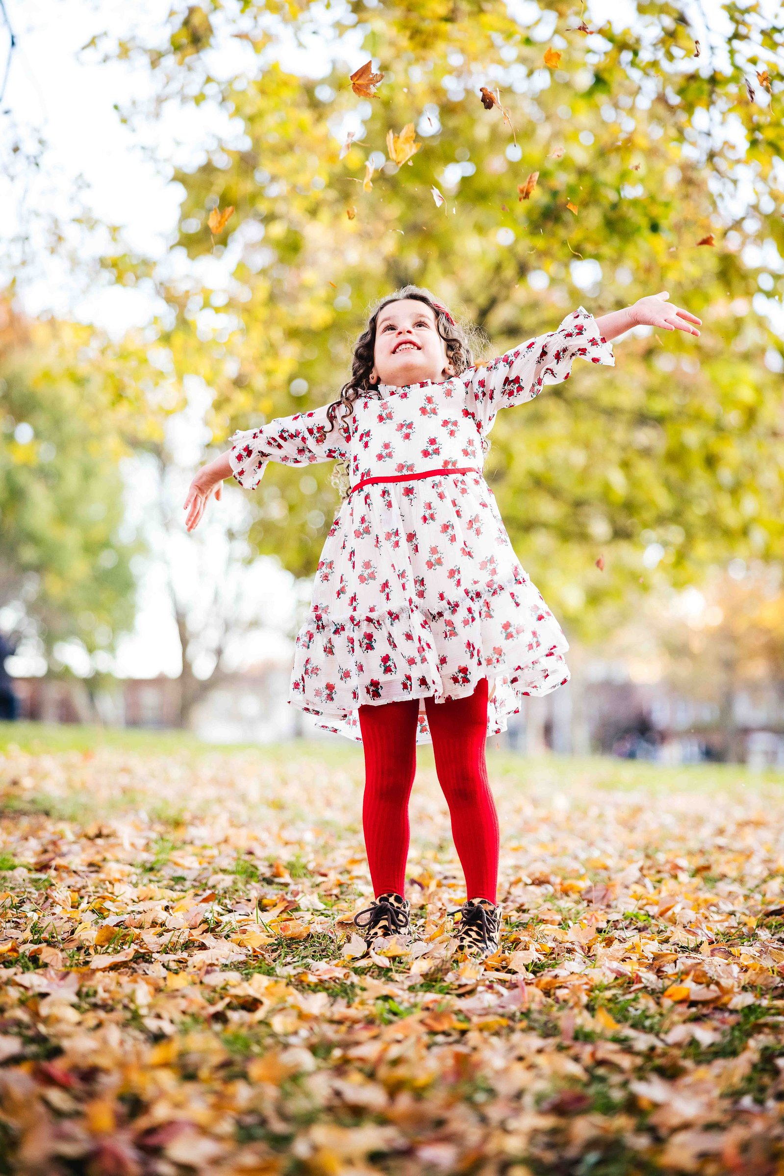 child playing in the fall leaves in Astoria Park, family portraits by mc3 photo. family portrait sessions New York  