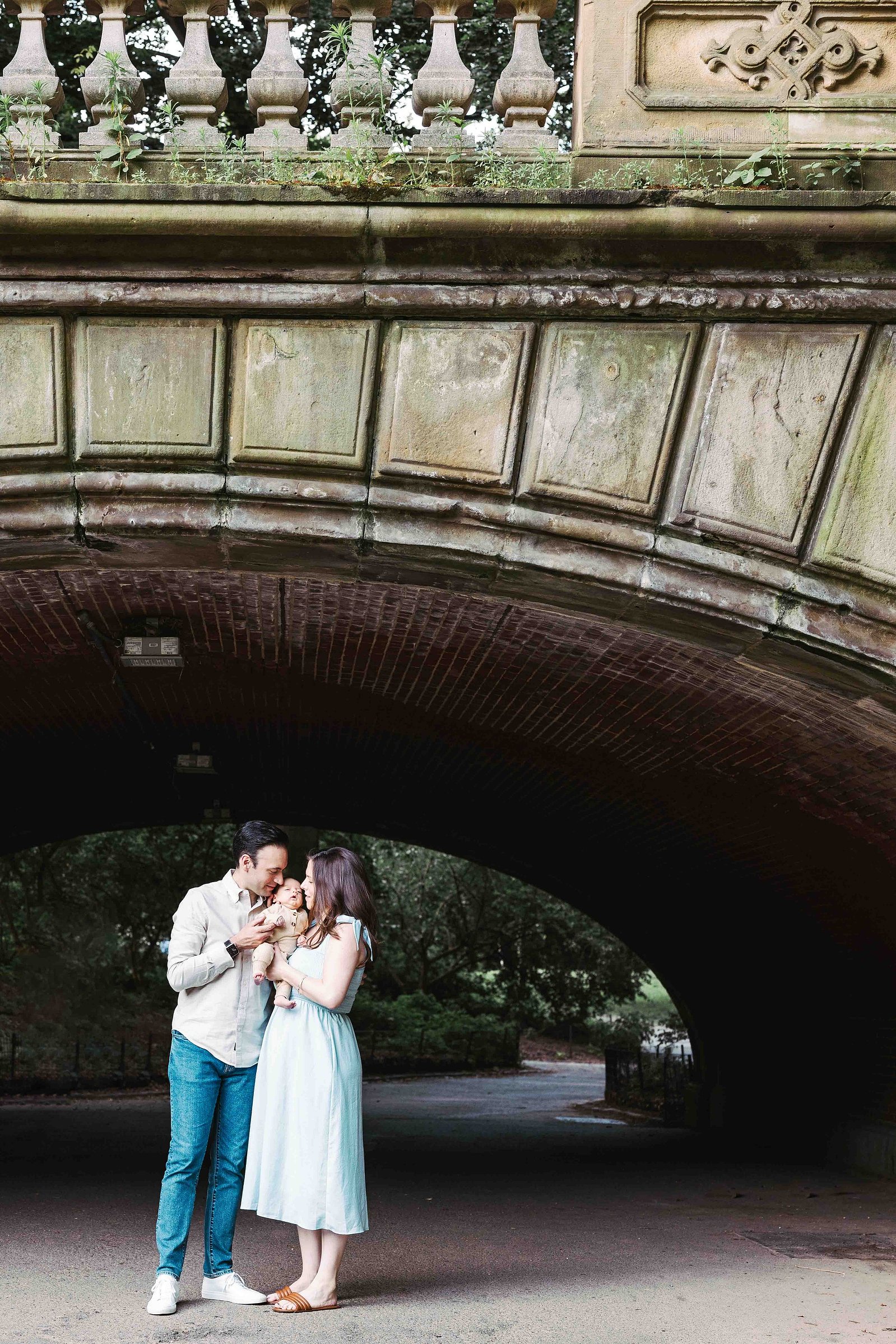Central Park family portrait session from mc3 photo. New York City photographer, family of 3 under arching bridge in Central Park nyc