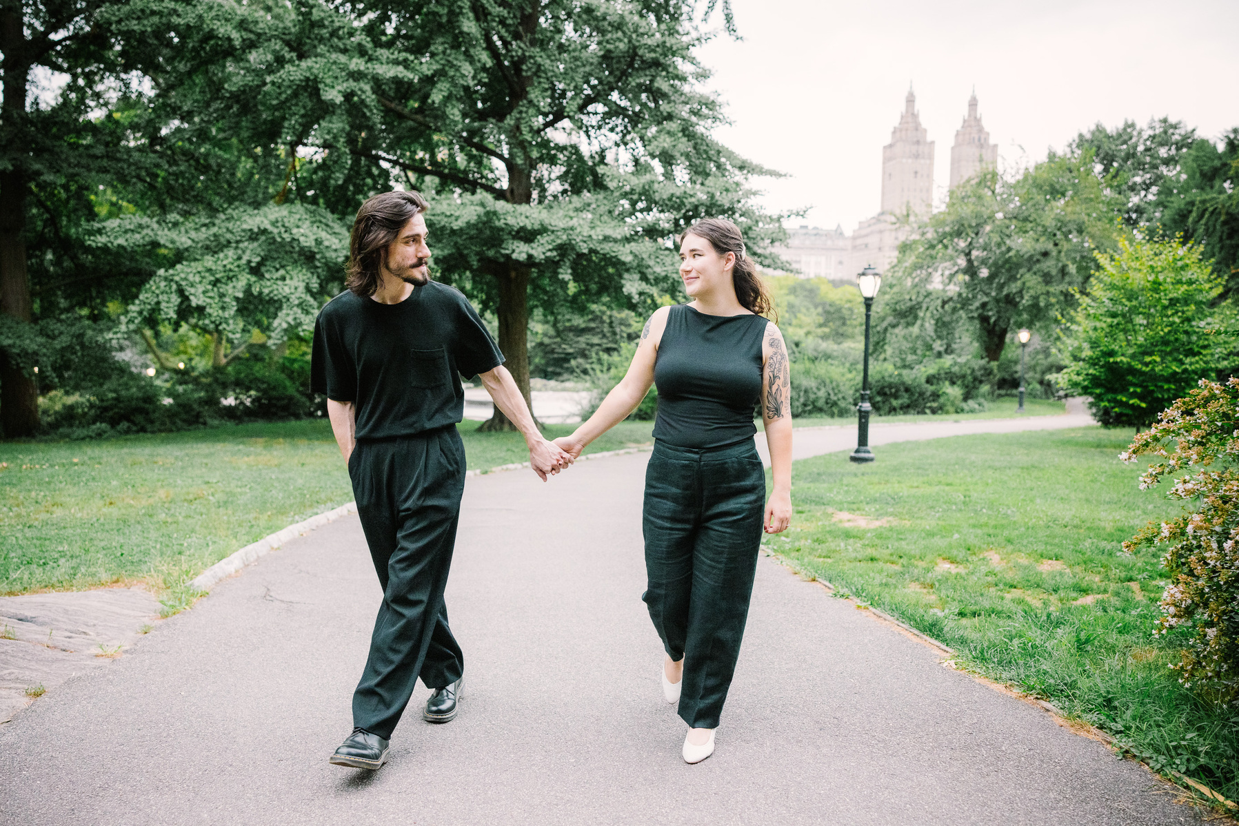a couple walking in Central Park, smiling and holding hands during a documentary engagement session, by mc3 photo 