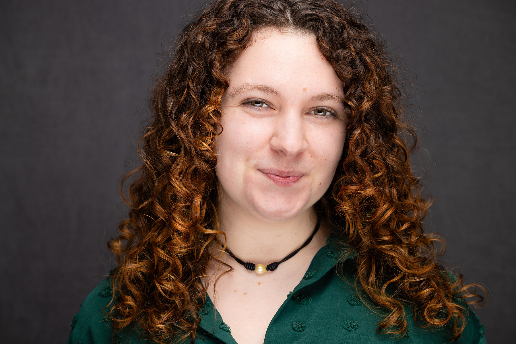 Hailey Crecca headshot in Long Island city. Curly hair and green shirt, mc3 photo boutique headshot. 