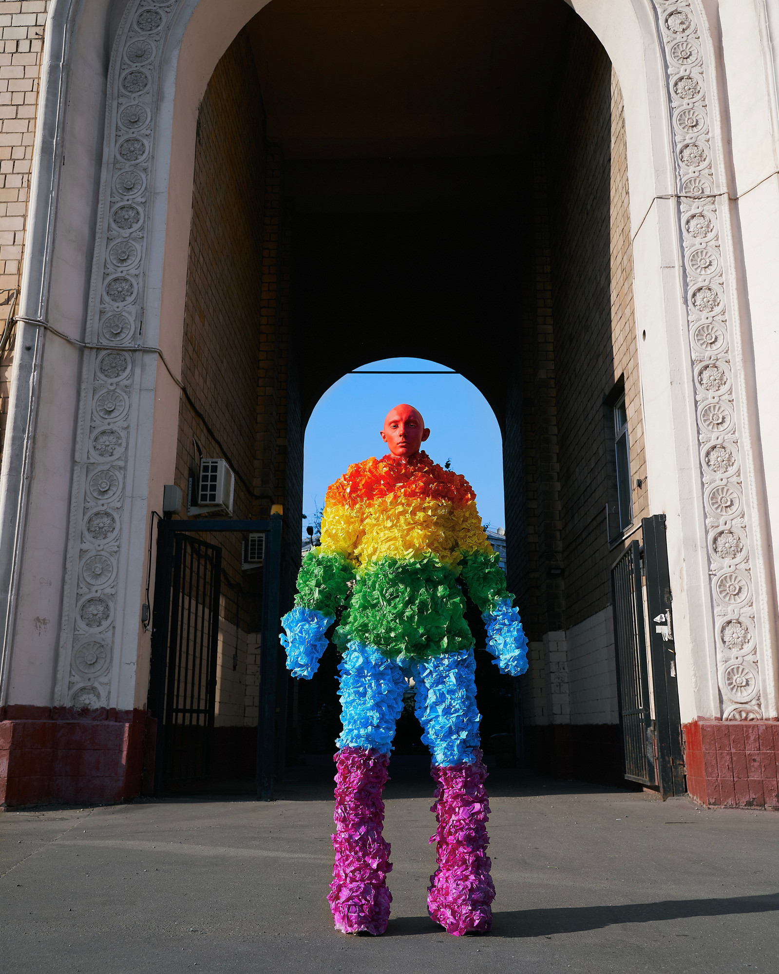 UTOPIA is a queer futures art exhibition in Amsterdam exploring the future of LGBT life through artificial intelligence, photography, art installation and video. Image of Gena Marvin wearing pride flag outfit. 