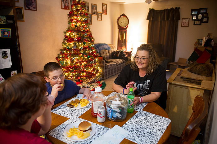 Hannah Turner, 16, left, eats dinner with her brother, Brason Darden, 8, and her mother, Crystal Causey, in their new home in Henderson, Thursday, Dec. 15, 2016. In their apartment they lacked space to eat meals around a table and Causey wanted a space in