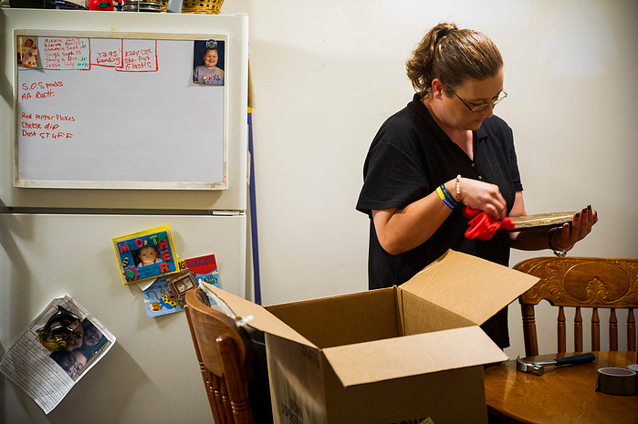 Crystal Causey, packs away pictures and other mementos from the kitchen in her apartment which she shares with her daughter, Hannah Turner, 16, and Brason Darden, 7, Tuesday, June 14, 2016.