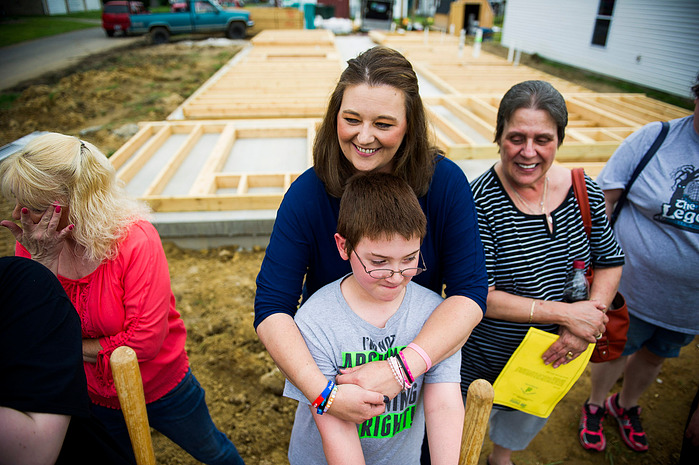 Crystal Causey, center, hugs her son, Brason Darden, 7, during the groundbreaking ceremony for their new home on Fifth Street in Henderson, Friday, June 3, 2016. Causey was making dinner when she initially received the phone call from Habitat for Humanity