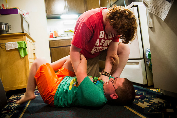 Hannah Turner, 16, wrestles with her brother, Brason Darden, 7, in the kitchen of their apartment, Tuesday, June 14, 2016.
