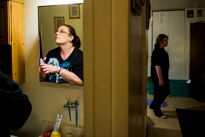 Crystal Causey, left, organizes the bathroom in their apartment as per daughter, Hannah Turner, 16, prepares for her shift at the Henderson Arby's restaurant, Wednesday, June 1, 2016. The family fights for space in their small apartment daily.