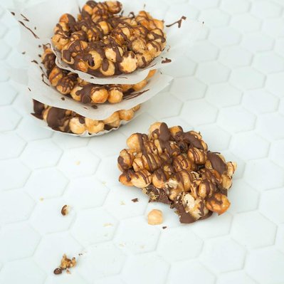 Roasted hazelnut, caramel and chocolate clusters on a white background, sweet treat, snack, dessert