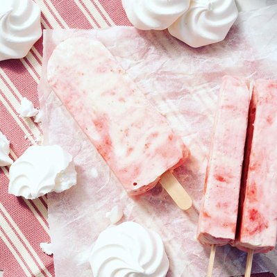 strawberries and crem ice lollies on baking paper with meringues popcicles summer treat, refreshing snack