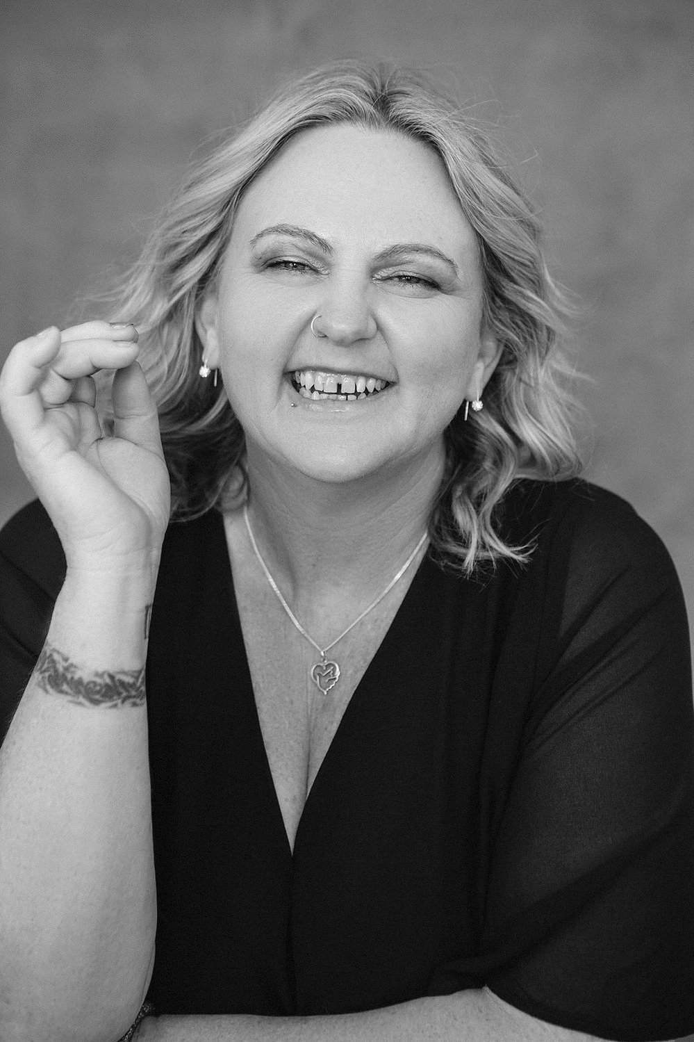 A curvaceous woman with a blonde bob beams at the camera