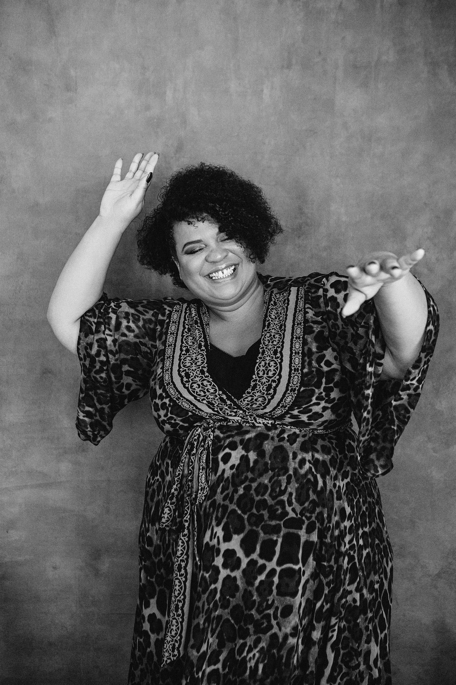 A joyful woman dances, her arms thrown up