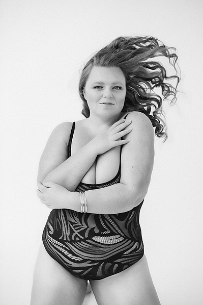 A curvaceous young woman throws her long hair back over her shoulder