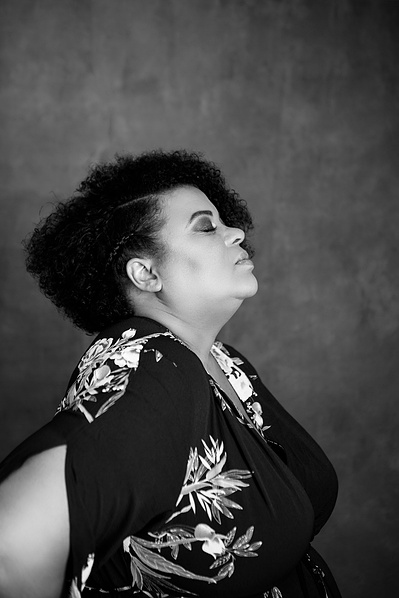 A curvaceous black woman in profile, eyes closed and head tilted back