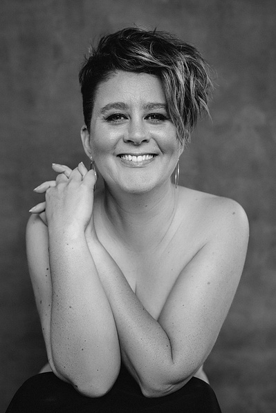 A woman with cropped brown hair smiles at the camera