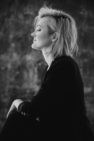 Profile view of a woman with short blonde hair swept away from the camera