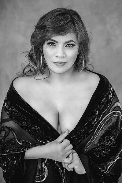 A woman stares evocatively at the camera, a kaftan draped around her torso