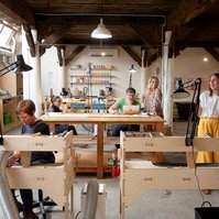 A large jewelry workshop filled with five workers, all on different tasks
