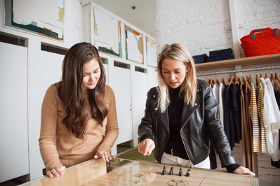 Two women in a shop using the Shopify hardware, showing the product in action.